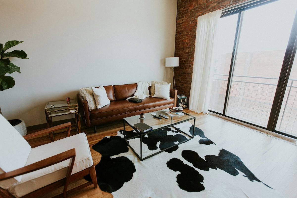 Western room decor with leather sofa and cowhide rug