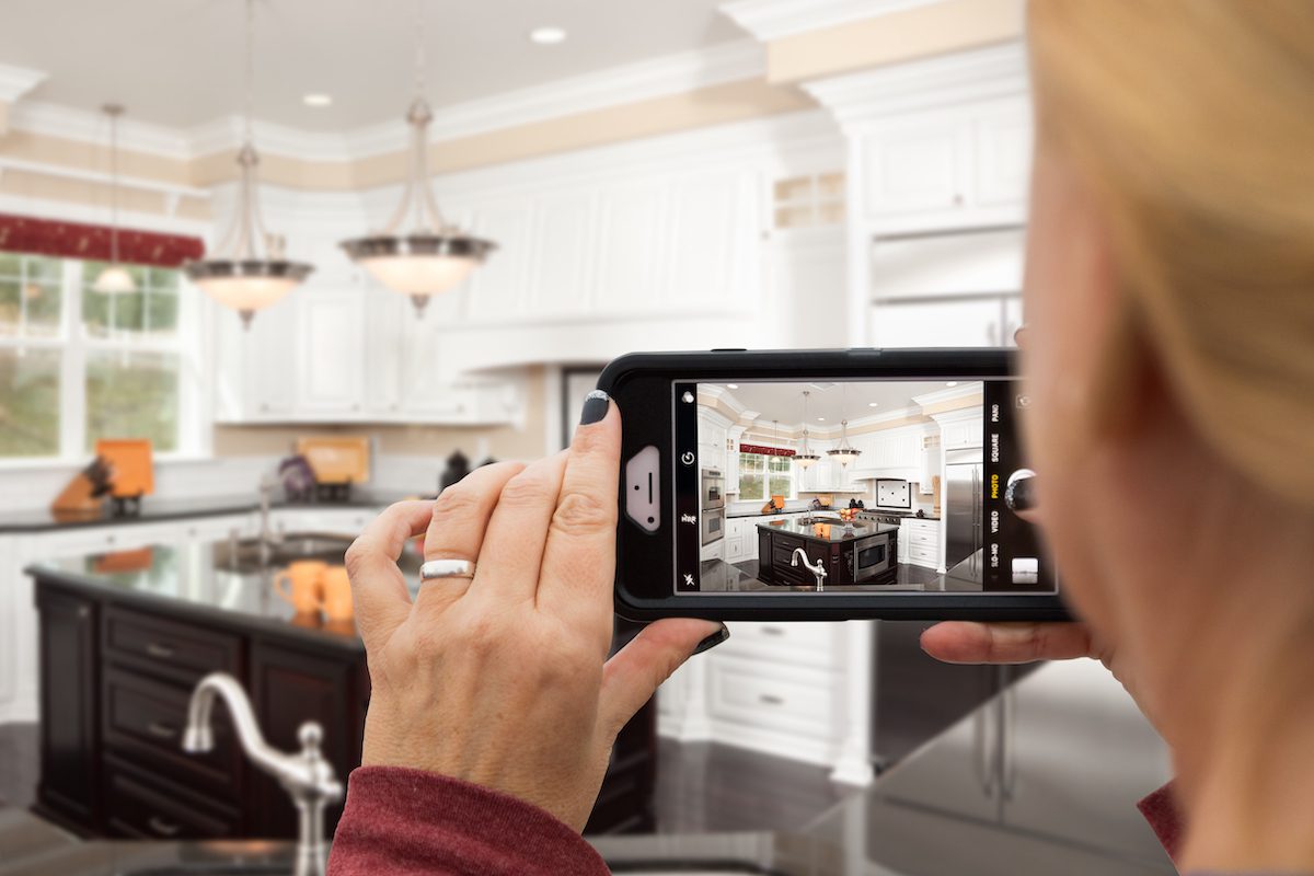 Woman taking picture of her kitchen